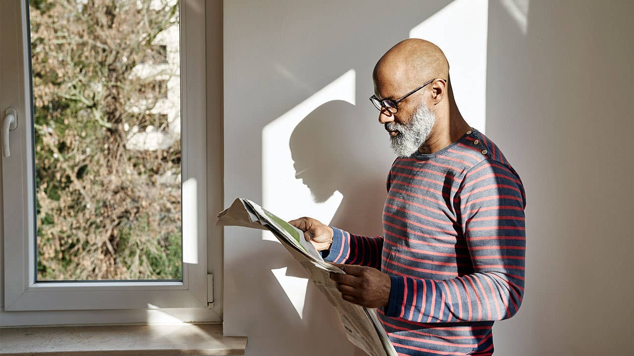 Bearded man reading newspaper