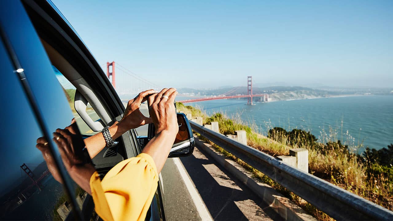 Woman taking a pic outside of a car