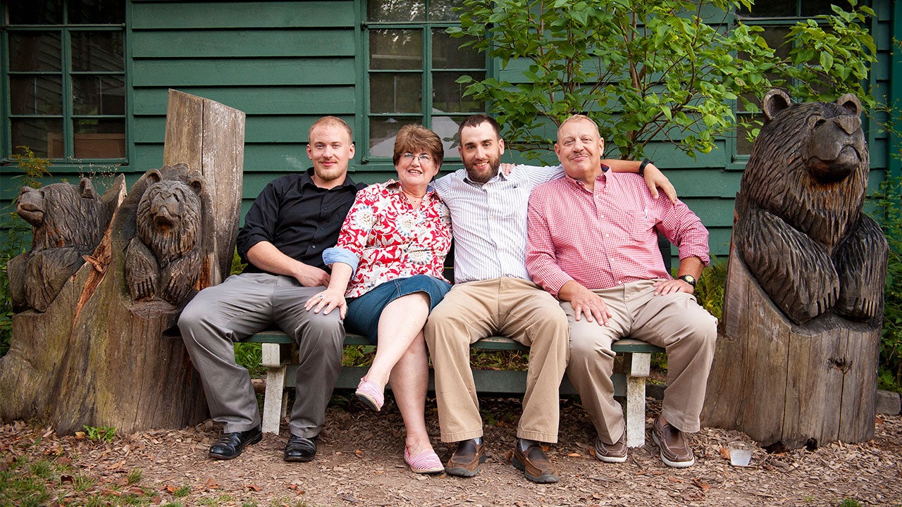 Adult children with their parents sitting on bench