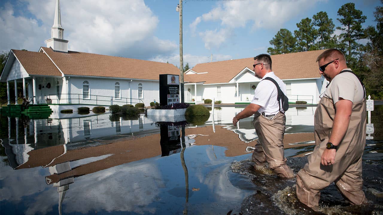 Men walking past church in the aftermath of Hurricane Florence