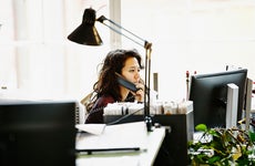 Woman talks on the phone in office