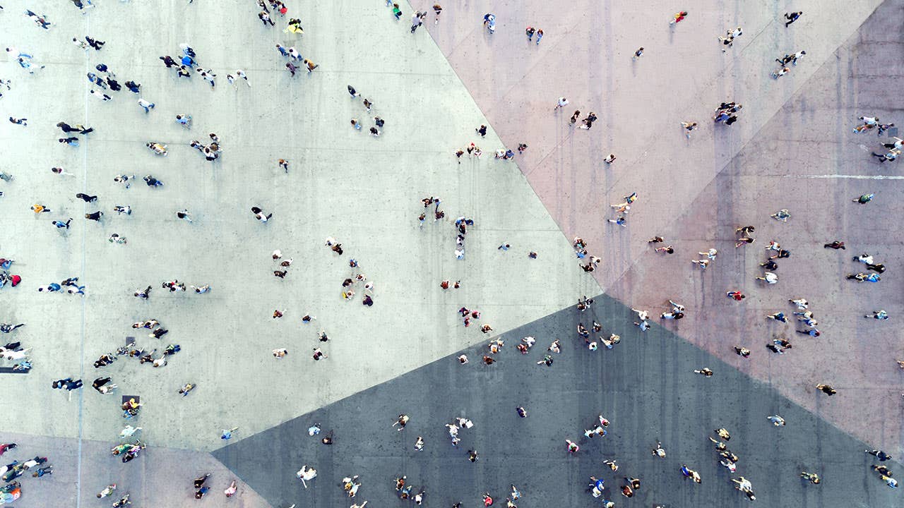 People walking across colored sidewalk