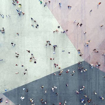 People walking across colored sidewalk