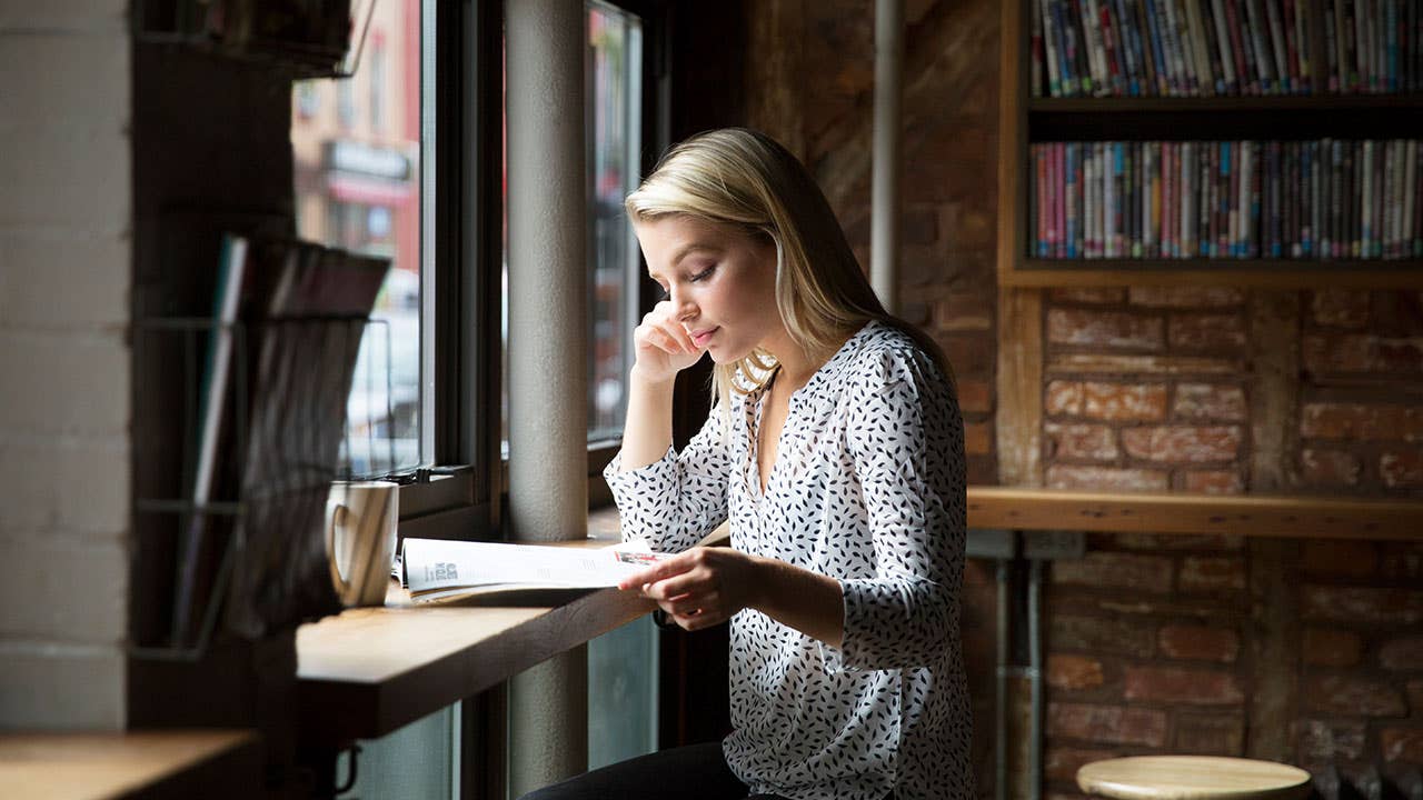 Woman in coffeeshop reviewing paperwork