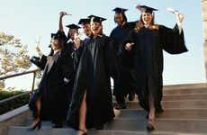 Group of excited graduates running down steps