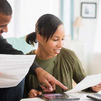 Young couple paying bills in living room