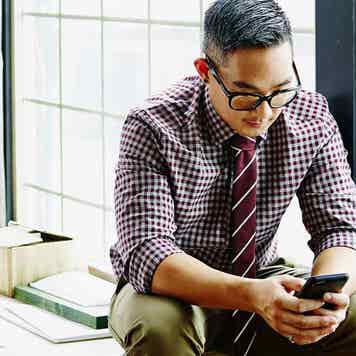 Professional young man working on smartphone in office