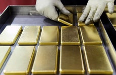 Worker stacking gold bars