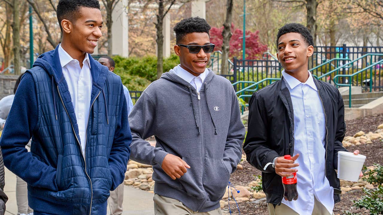 Millennial men walking in city park