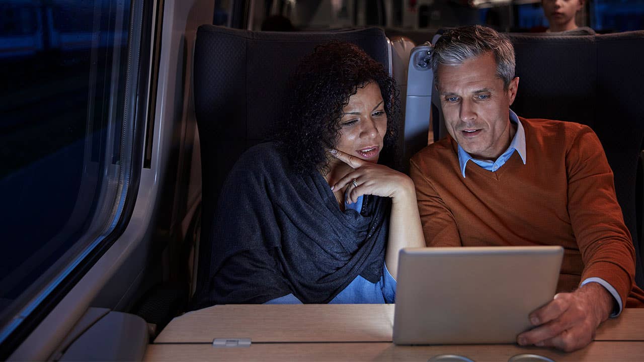 Couple on train looking at tablet