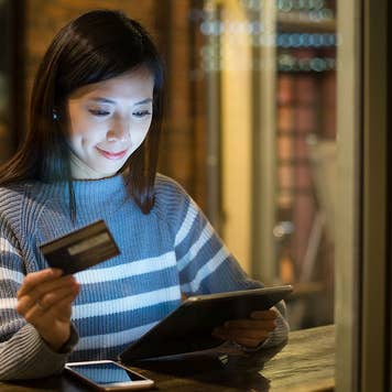 Woman paying with credit card on tablet