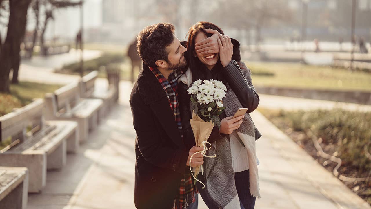 Man surprising girlfriend with flowers