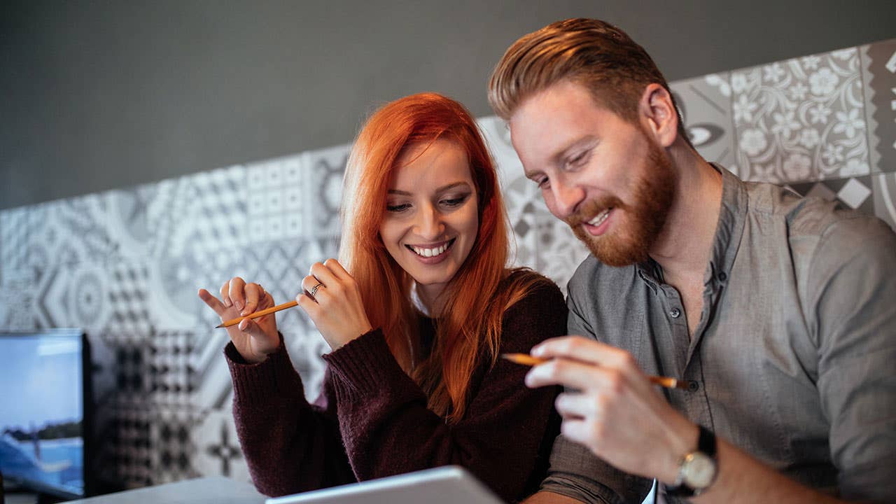 Couple looking at paying debts on tablet