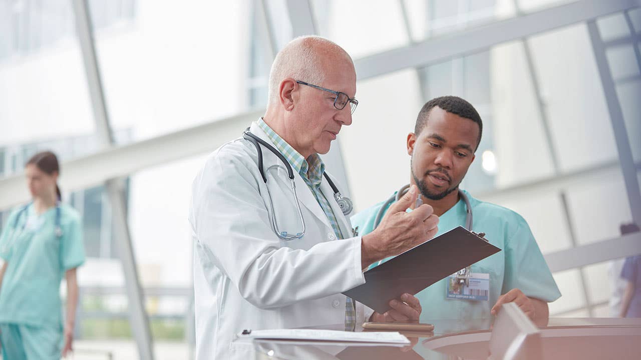 Older doctor talking with nurse