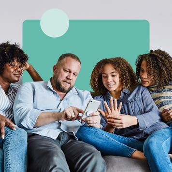 family sitting on a couch on mobile device