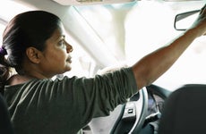 Woman checking rearview mirror of vehicle
