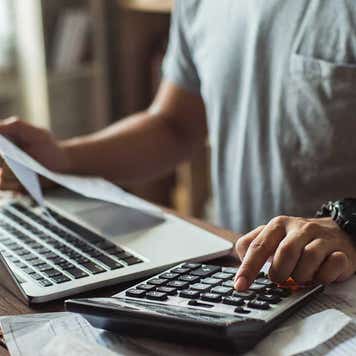 Man calculating bills in home office