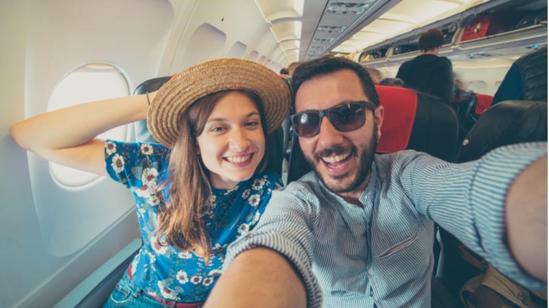 Young couple take selfie on airplane