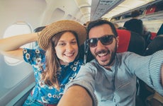 Young couple take selfie on airplane