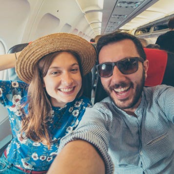 Young couple take selfie on airplane