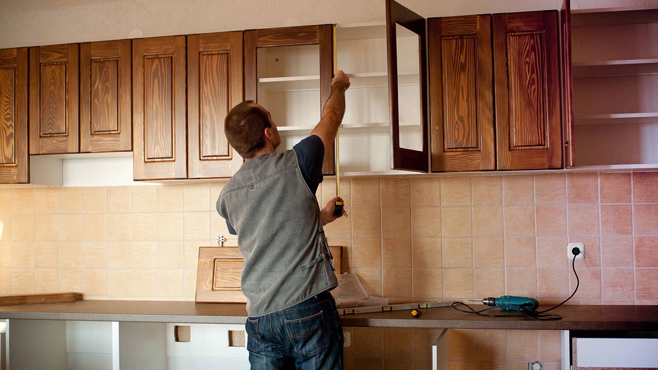 Man installs cabinets