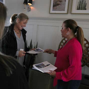 Women working with realtor and an open house