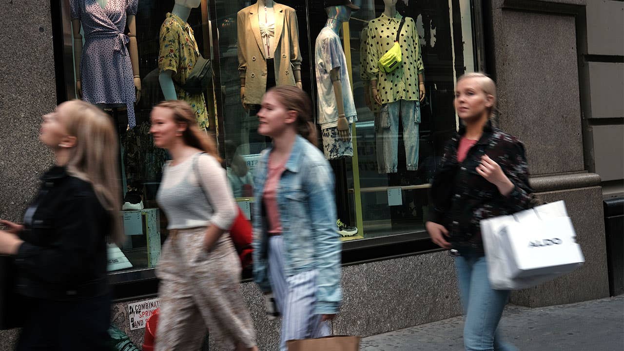 Shoppers walk down the street with shopping bags