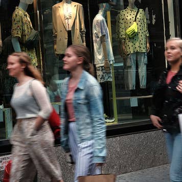 Shoppers walk down the street with shopping bags
