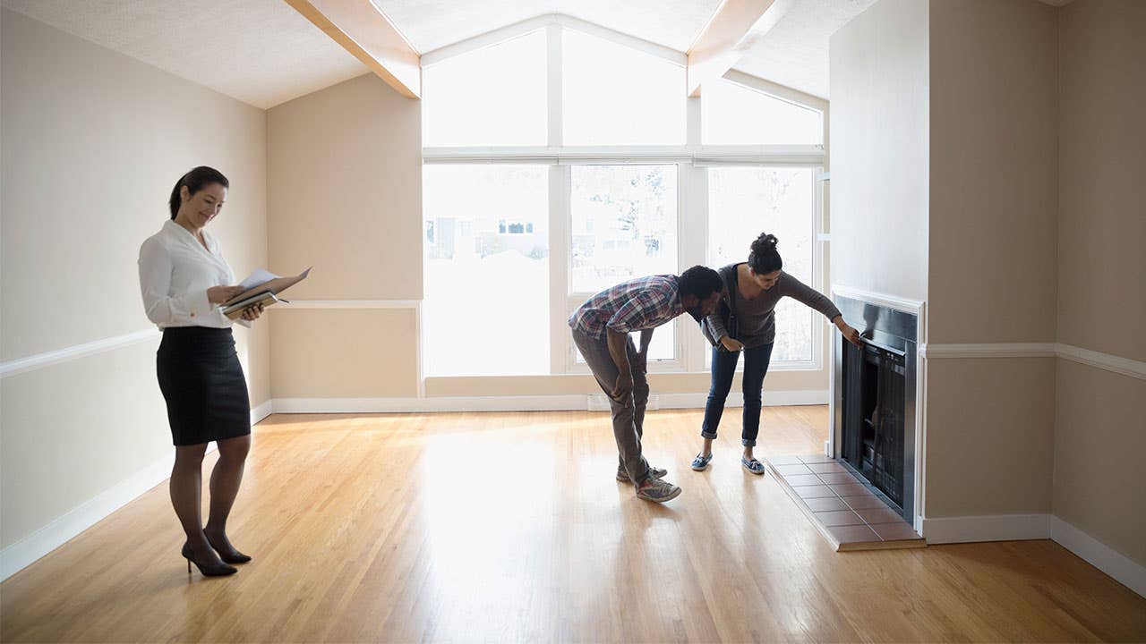 Couple inspecting a fireplace in a home walk through