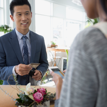 Man paying florist for bouquet in flower shop