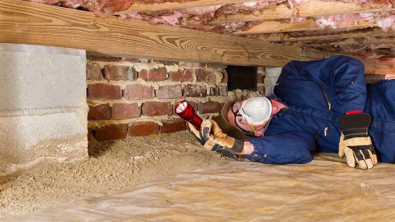 Home inspector looking under insulation
