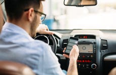 man using phone to check car insurance rates