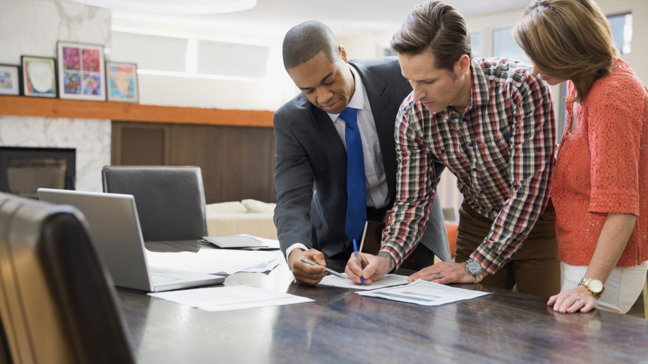 Couple signing financial paperwork