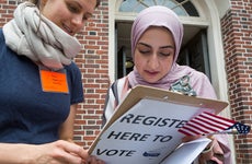 A new American citizen, originally from Iraq, registers to vote immediately after a naturalization ceremony in Faneuil Hall, on June 7, 2018 in Cambridge, Massachusetts. More than 300 people became Americans.