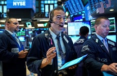 Traders on the floor of the New York Stock Exchange react to news