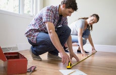 Couple measuring a hardwood floor