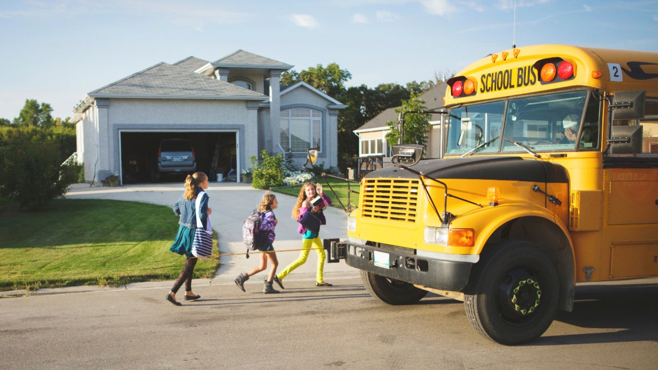 Children getting off a school bus to go home.