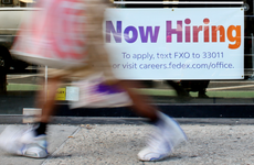 A "Now Hiring" sign is displayed on a shopfront