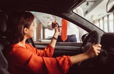 woman receiving key for rental car