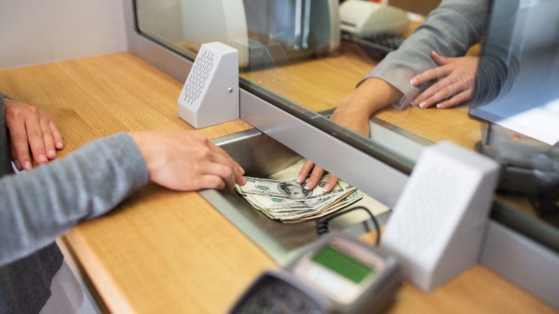 A picture of a customer depositing money at a bank to open a CD