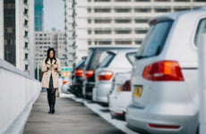woman texting next to a row of cars