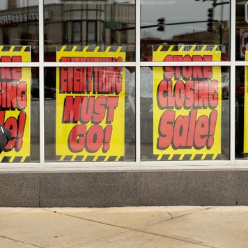 Signs in the window of a Sears store advertise its closing.