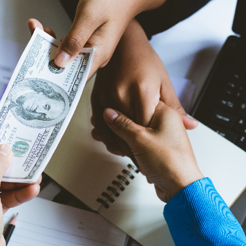 hand shaking, exchanging money across desk