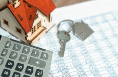 A calculator and house keys on top of financial records