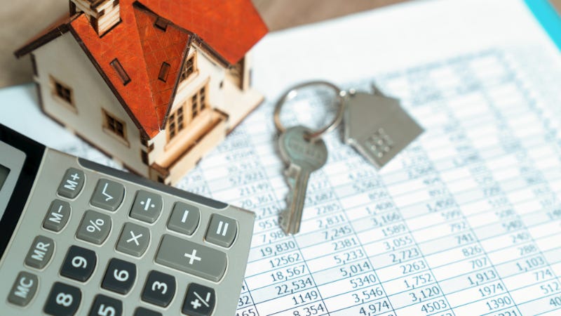 A calculator and house keys on top of financial records