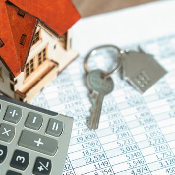 A calculator and house keys on top of financial records