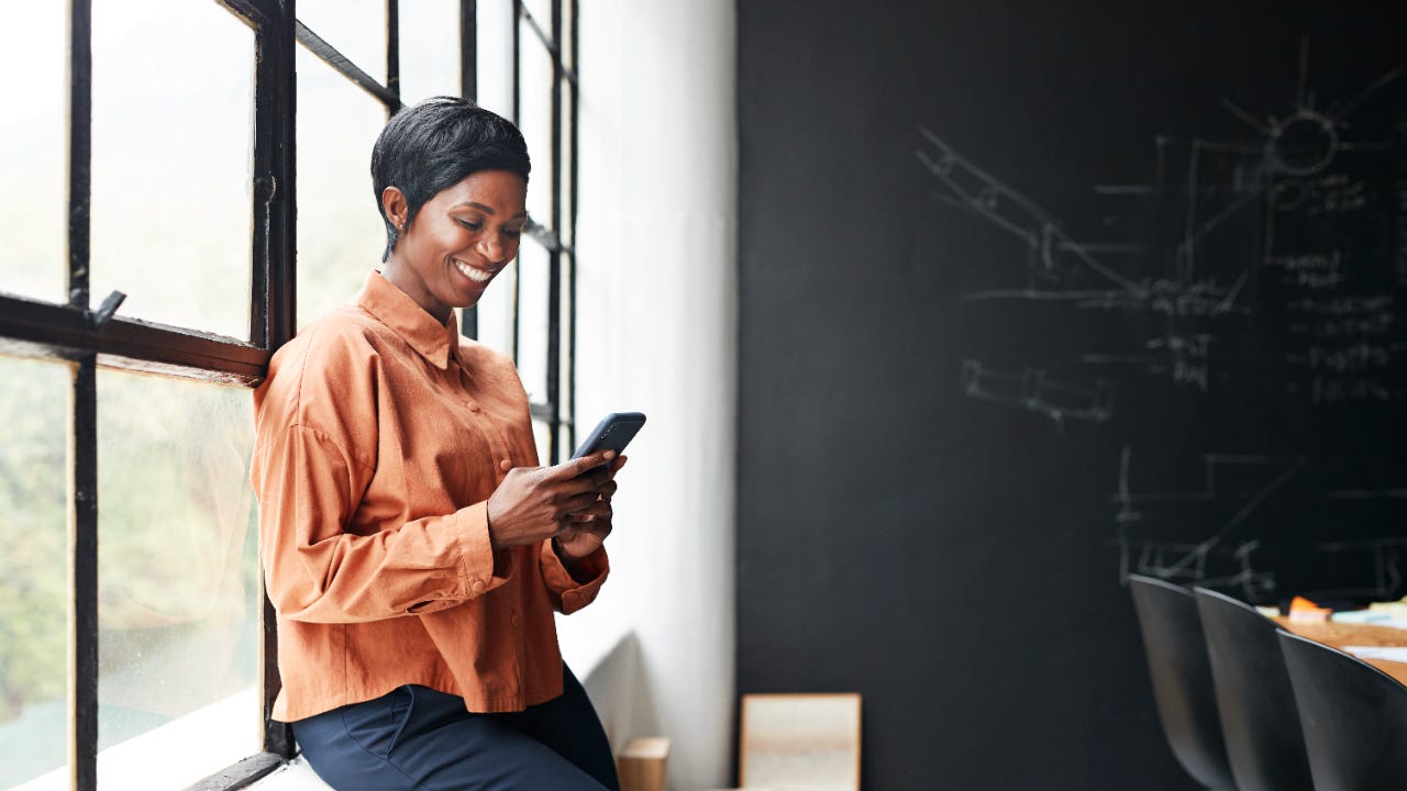 A woman holds a phone at an office