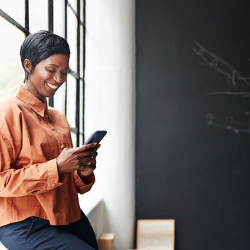 A woman holds a phone at an office