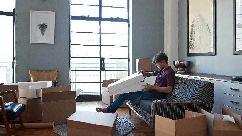 A man unpacking boxes in an apartment