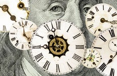 Clocks are displayed across an image of a dollar bill.